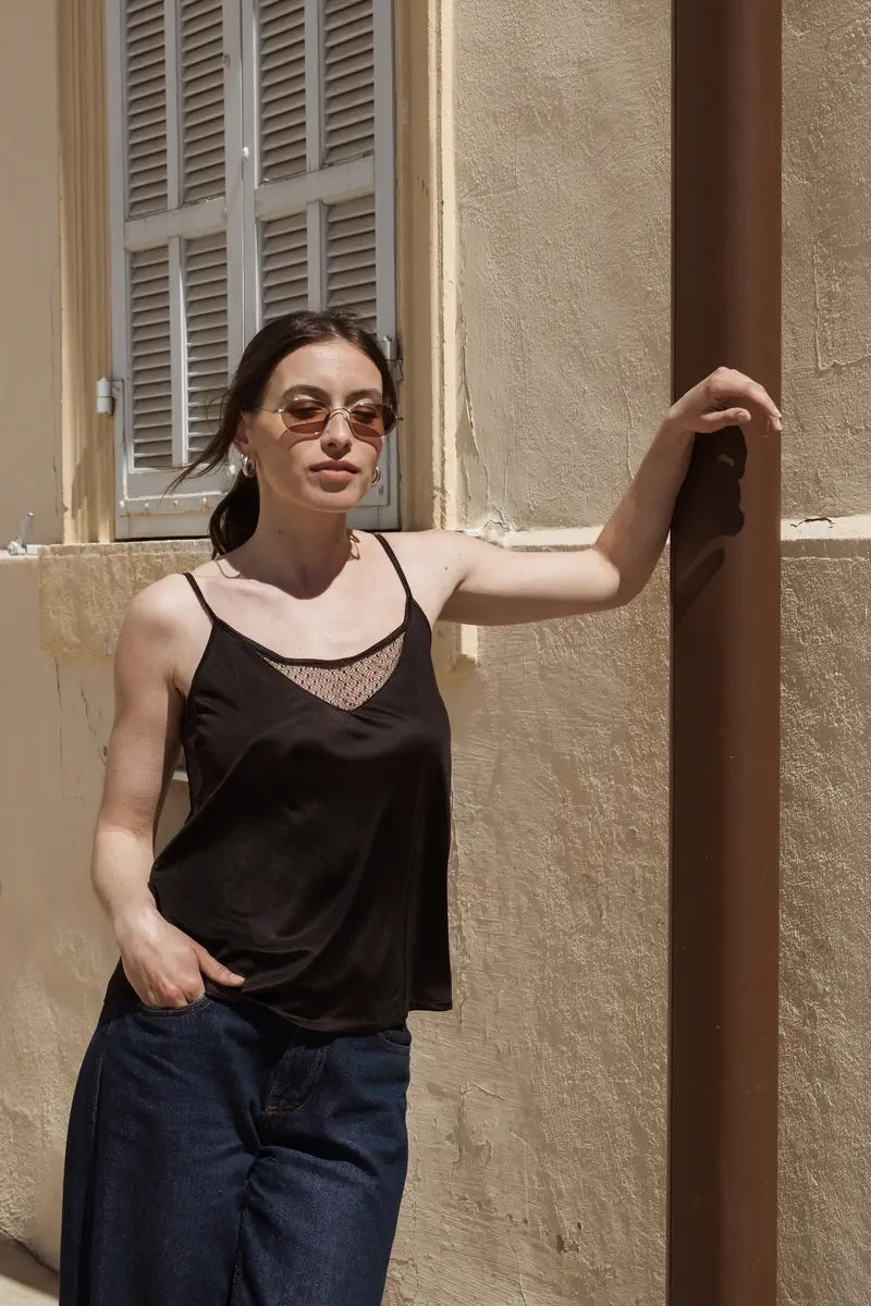 Femme avec un haut noir et un pantalon bleu marine