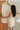 Fond de robe invisible Jules en laine mérinos et soie blush, porté en tenant une robe sur cintre – yvo et moi