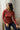 Femme assise près d'un rideau, portant le sous-pull Victor rouille en laine mérinos et soie, maille lisse, avec un pantalon bleu marine – yvo et moi